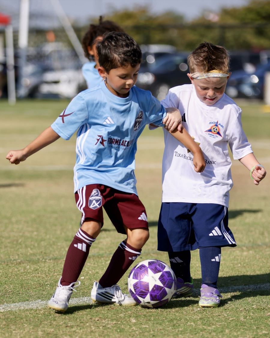 Two players contesting the ball in a Forms Academy match