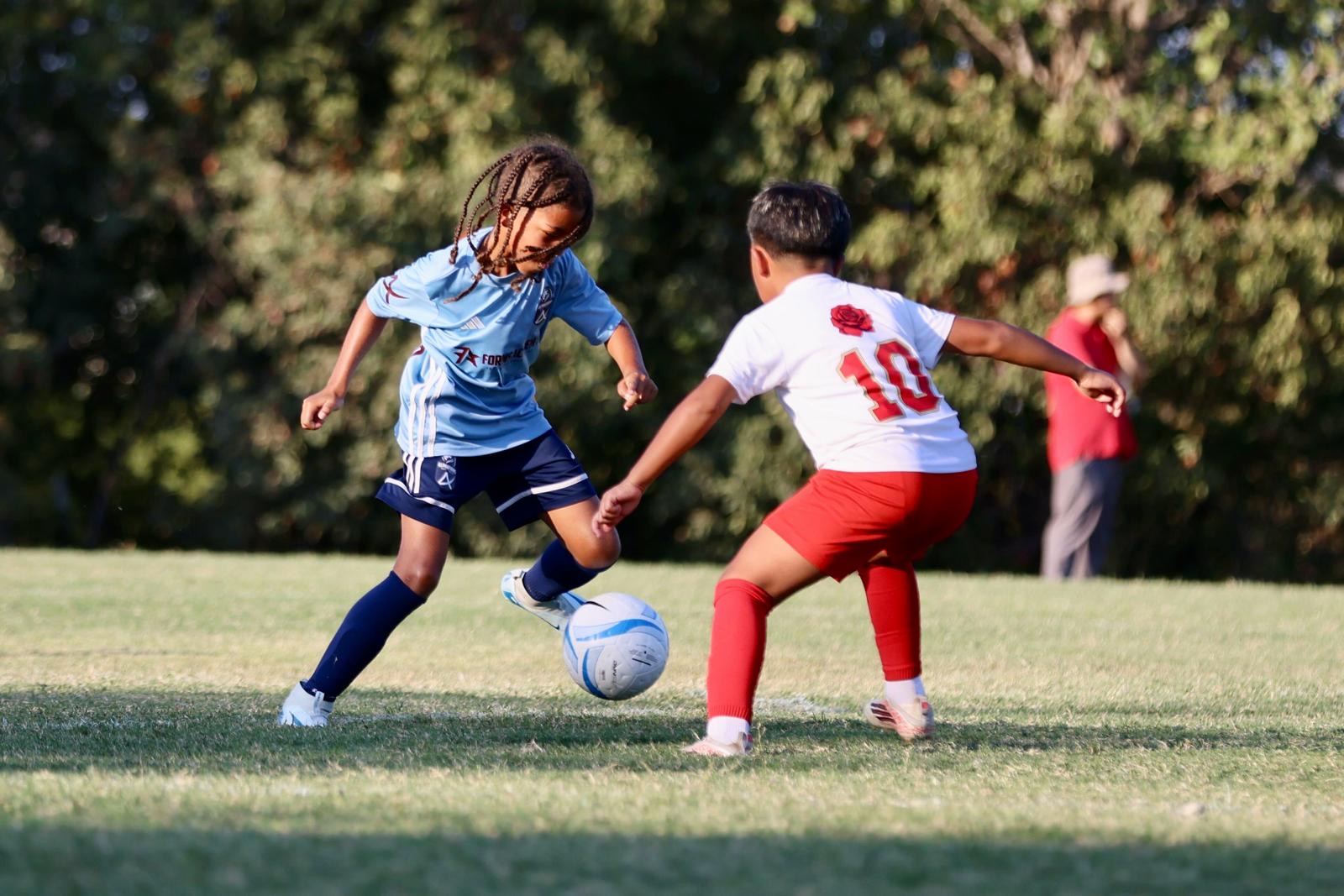 A Forms Academy player taking the ball at a defender